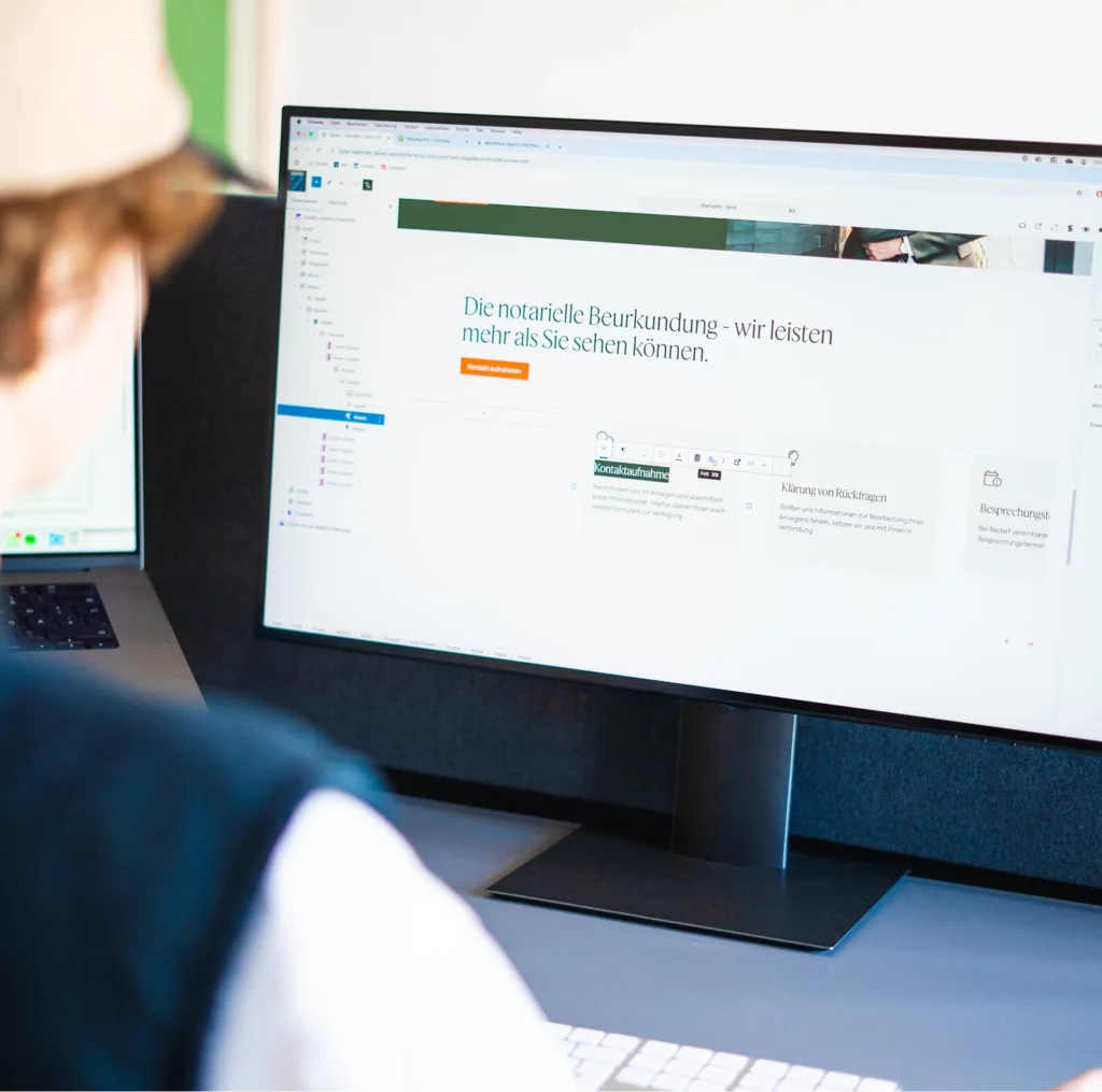 Person sitzt vor einem Computerbildschirm, auf dem eine Website Backend in WordPress zu sehen ist.